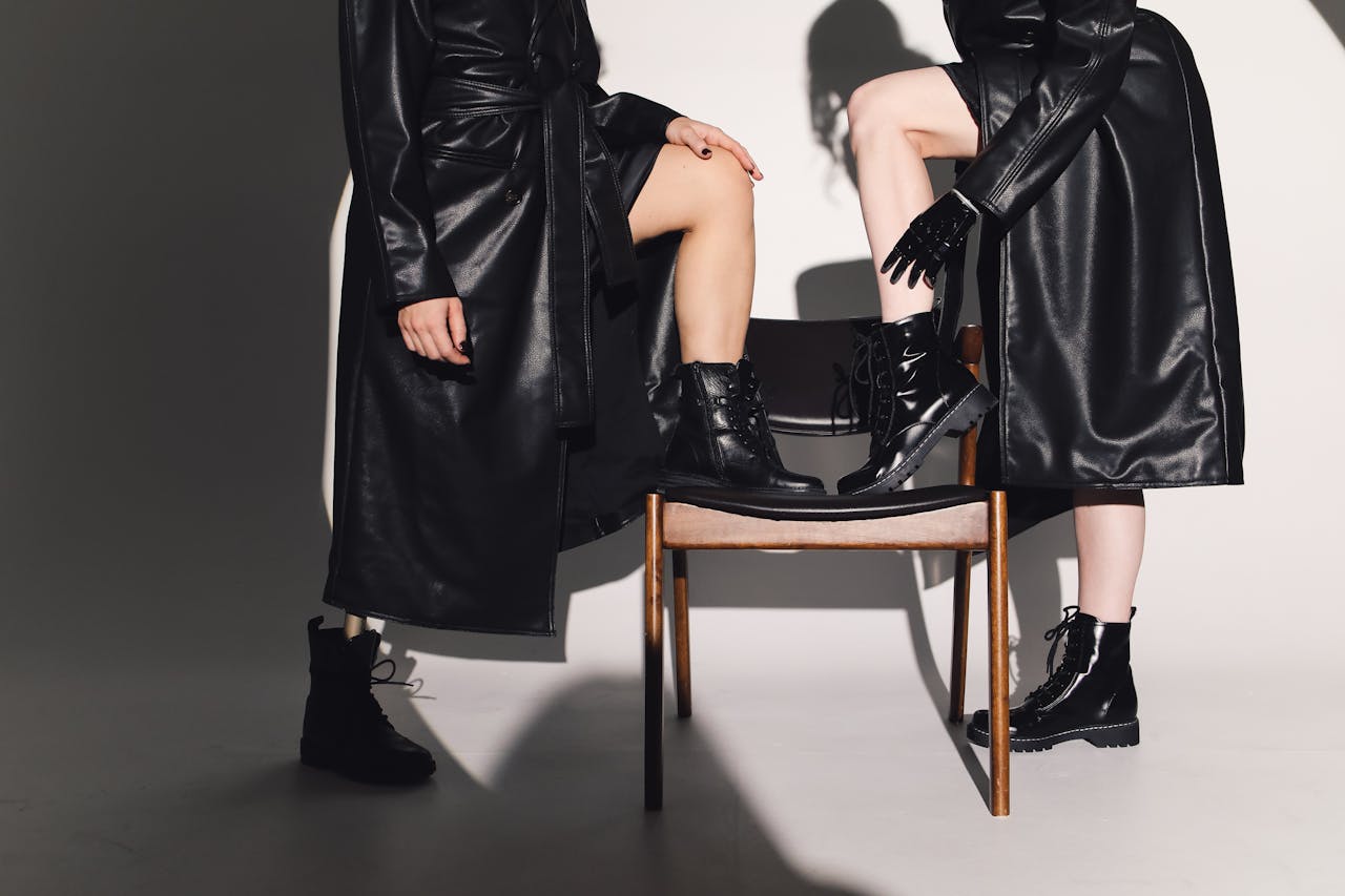 Chic editorial shot of models in black leather trench coats posing stylishly.
